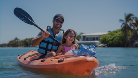 Father and daughter kayaking on waterway