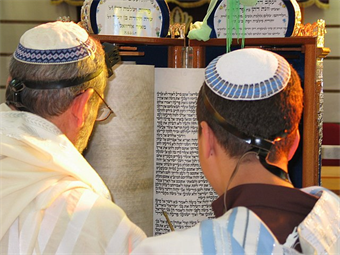 Men with kippot reading the Torah